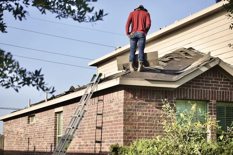 Professional roofer working on a residential roof in Pender